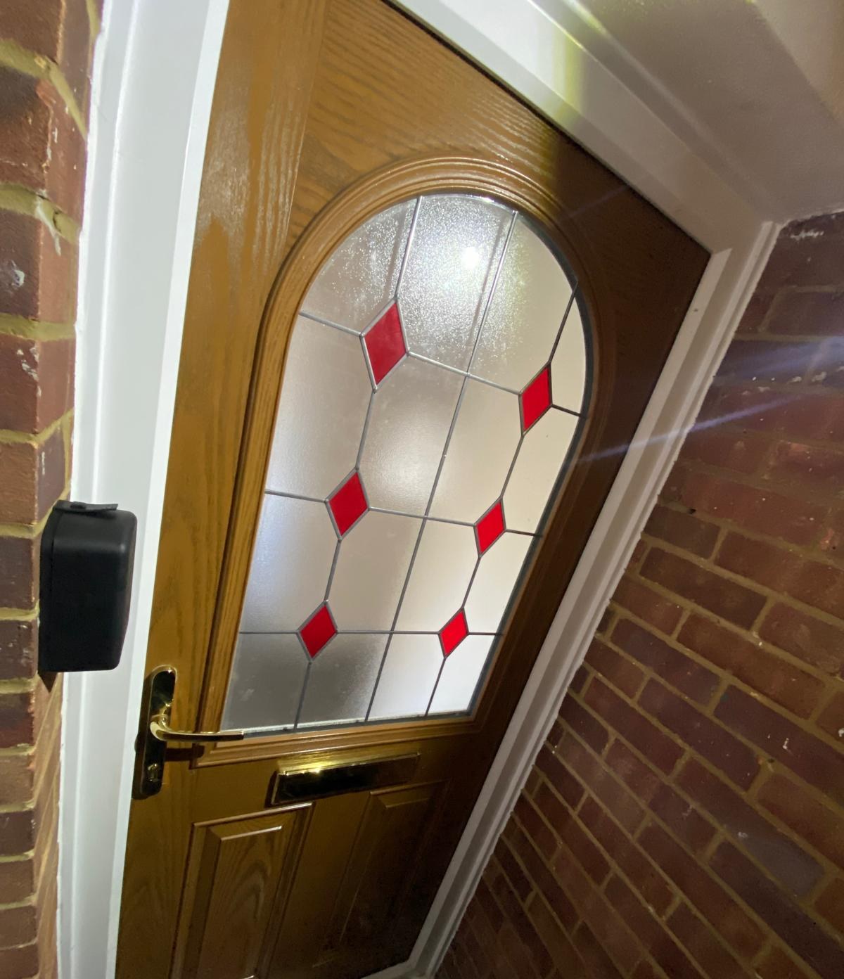 Wall-mounted key safe fitted beside a wooden front door